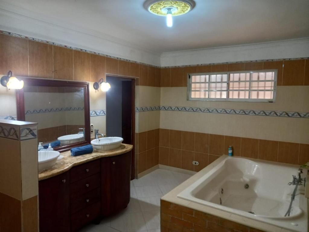 圣多明各Penthouse con jacuzzi La cueva de los 3 ojos的大型浴室设有两个盥洗盆和浴缸。