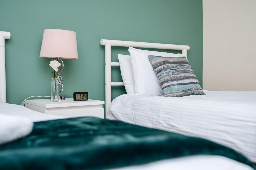 WoodhouseWoodhouse Lodge的一间卧室设有蓝色的墙壁和一张带枕头的床