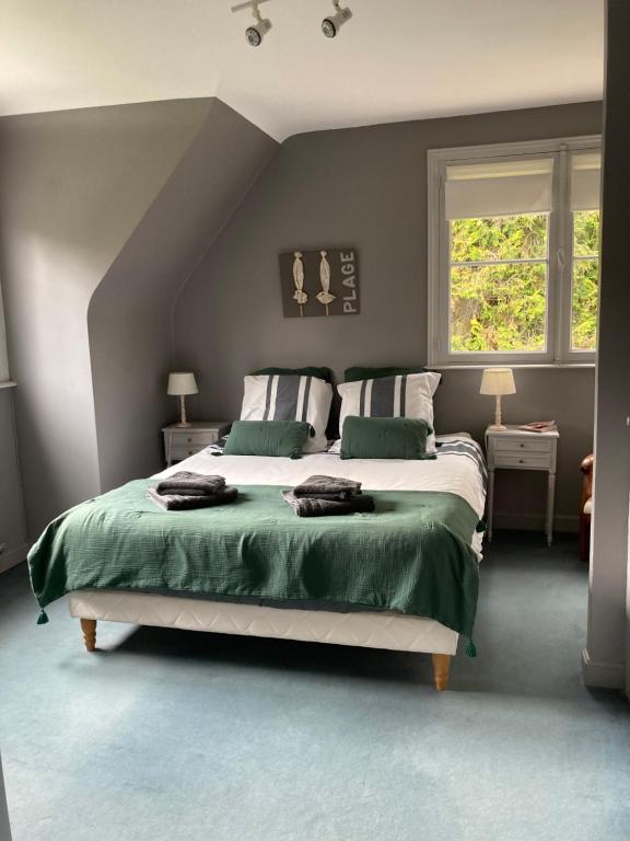 CroixLes Glycines的一间卧室配有一张带绿色床单的大床