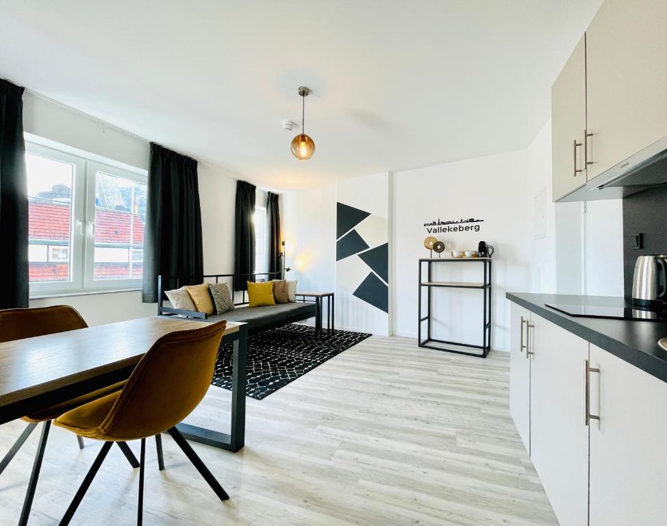 法尔肯堡City Apartments Grendelplein的厨房以及带桌椅的起居室。