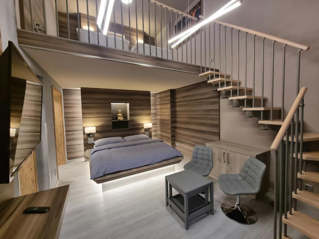 卡丹Apartmány Etenia的一间卧室设有一张床和一个楼梯