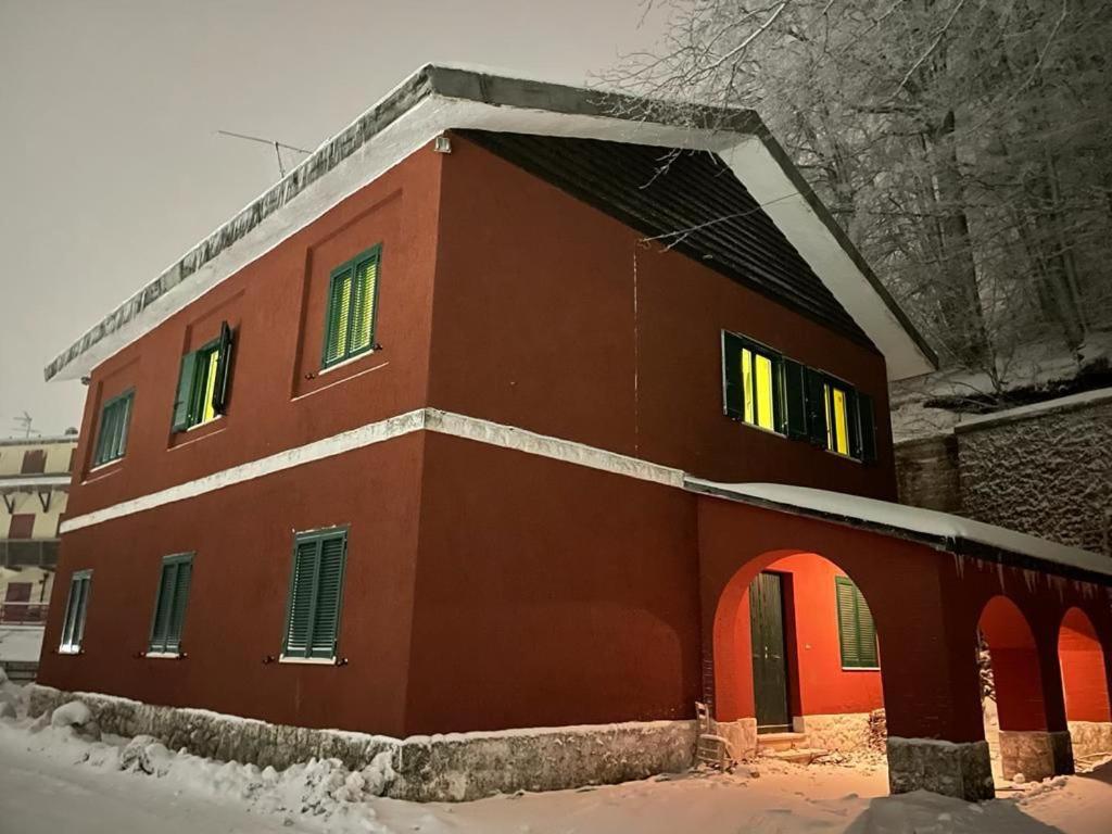 泰尔米尼洛La cantoniera dei 18的一座红色的建筑,地面上积雪
