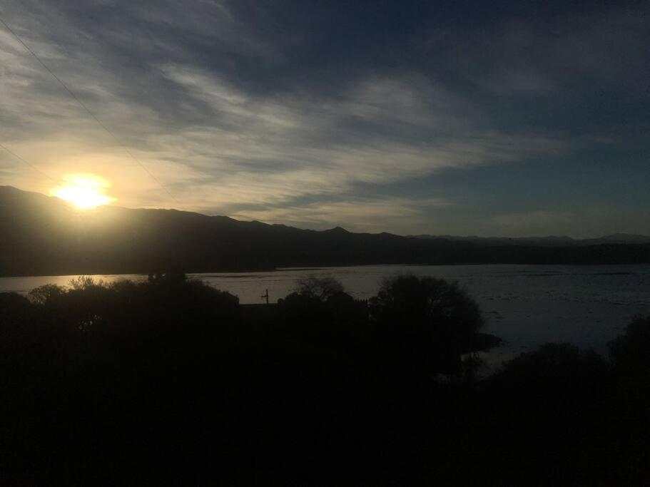 塔里哈Cabaña a orillas del Lago的日落在水体上,太阳在天空中