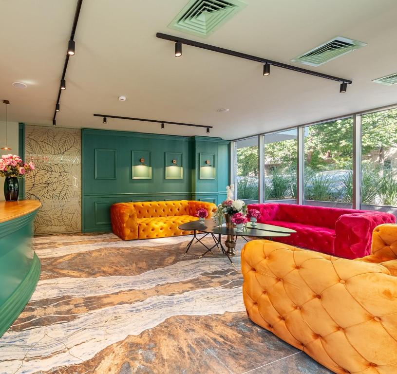 布加勒斯特Tomis Garden Aparthotel Bucuresti的客厅设有黄色和红色的家具和绿色的墙壁