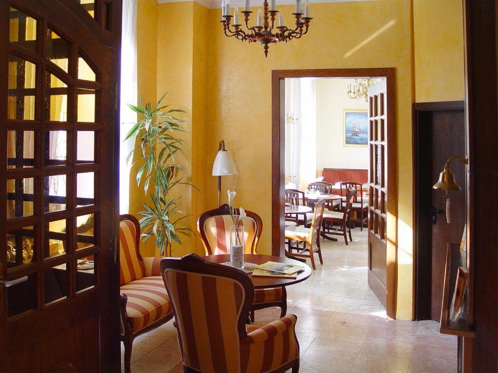 罗斯托克旧海港大厦酒店的一间带桌椅的房间和一间用餐室