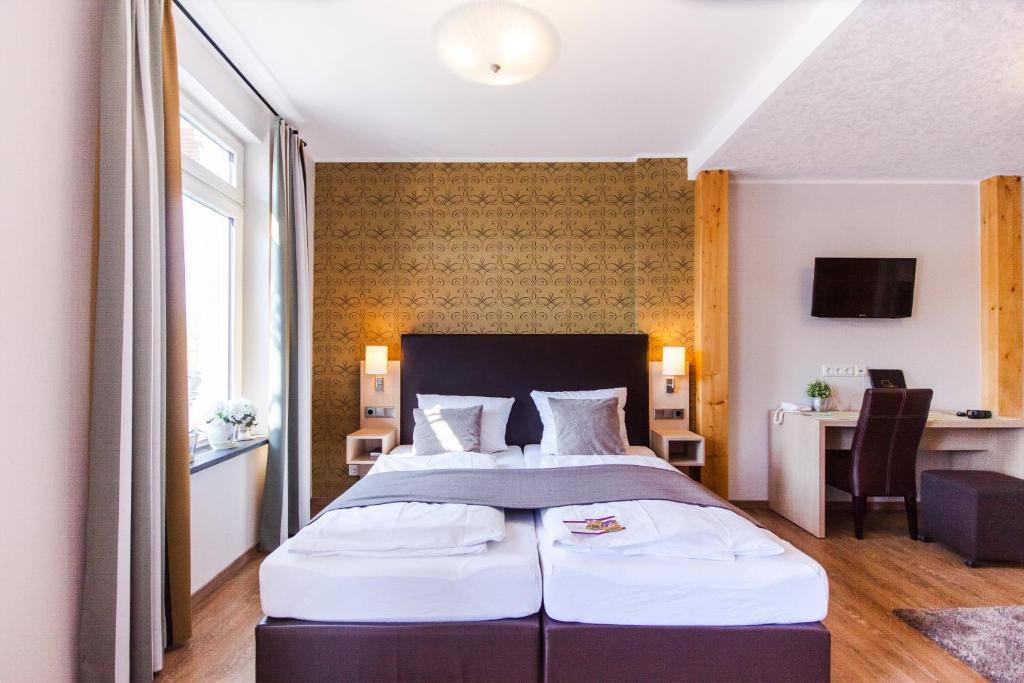 摩泽尔河畔的泽尔梅耶韦恩酒店的一间卧室配有一张大床和一张书桌