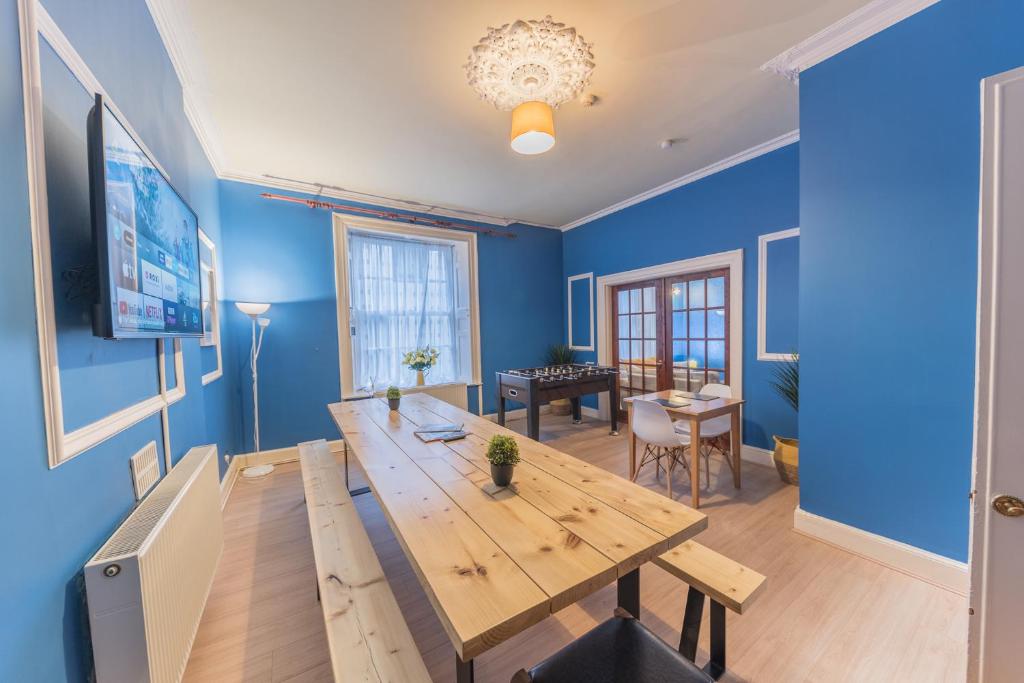 怀特黑Tivoli Guesthouse的一间设有木桌和蓝色墙壁的用餐室