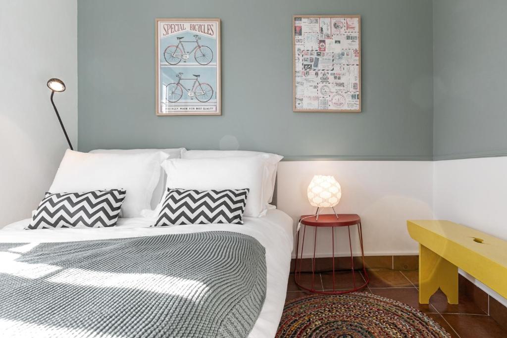 邦巴拉尔Flat 23的一间卧室配有一张带两个枕头和一张桌子的床。