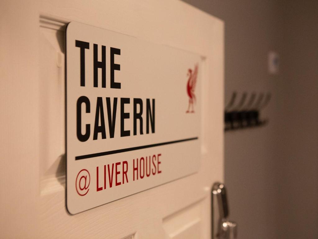 Rock FerryThe Cavern Apartment @ Liver House的看小酒馆的门上的标志