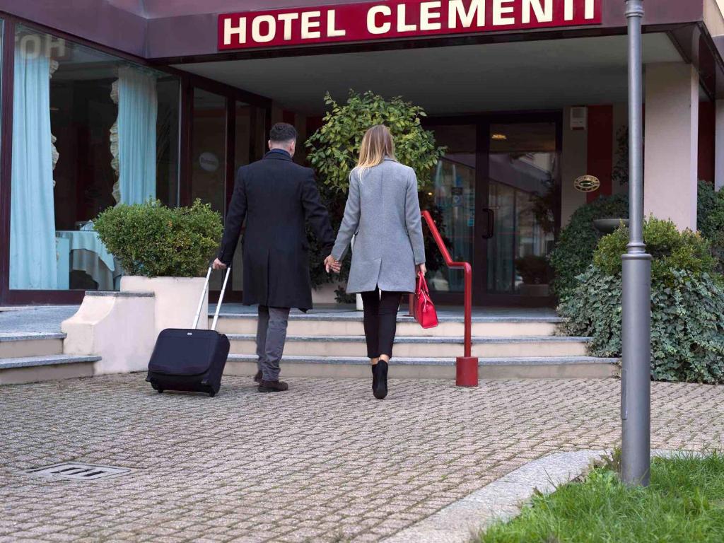 萨利切泰尔梅克莱门蒂酒店的带着行李走进酒店的男人和女人