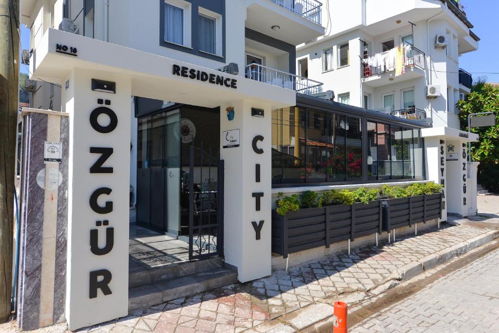 费特希耶Ozgur City Residence的一座标有红崖居所标志的建筑