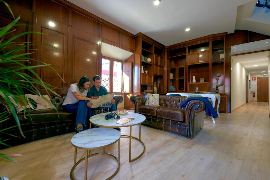 普拉森西亚Casa de las Argollas Dúplex Grand Suite的两人坐在客厅的沙发上