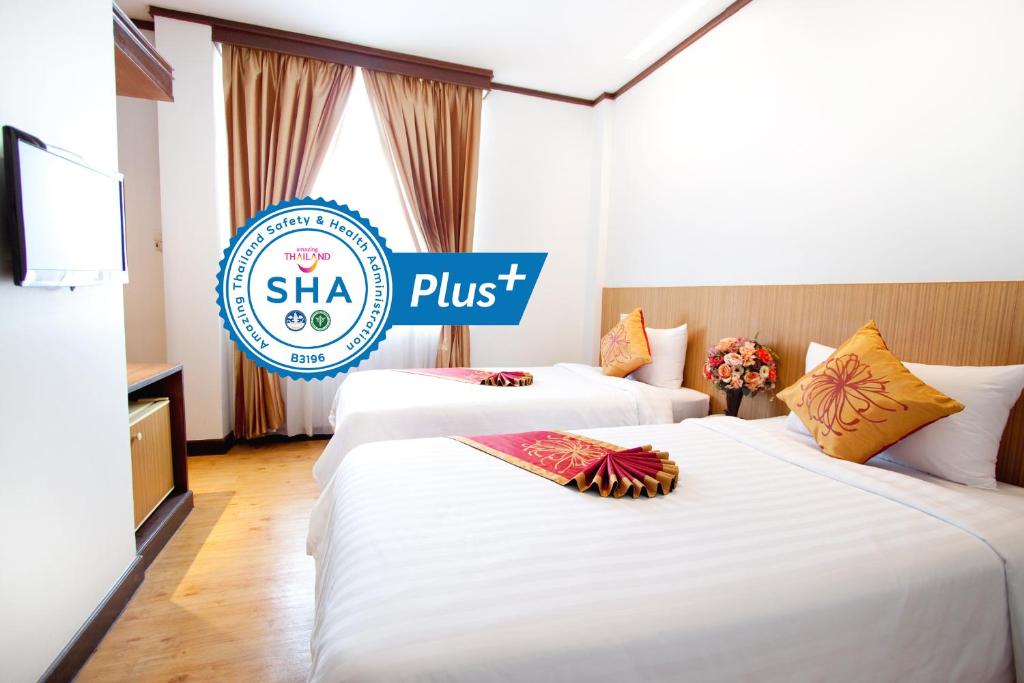 曼谷China Town Hotel - SHA Plus Certified的标牌的酒店客房内的两张床
