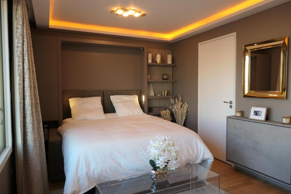 巴黎Luxury Studio Daumesnil Wifi & Netflix的一间卧室配有一张铺有白色床单和鲜花的床。