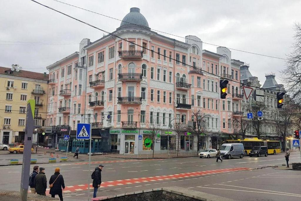 基辅Maison Blanche Kyiv city center的街道拐角处的一座粉红色大建筑