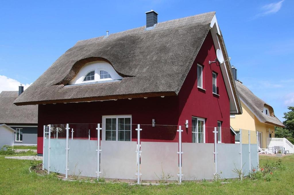 维埃雷格Ferienhaus Lotsenhaus am Breetzer Bodden in Vieregge的红色的房子,屋顶有 ⁇ 墙