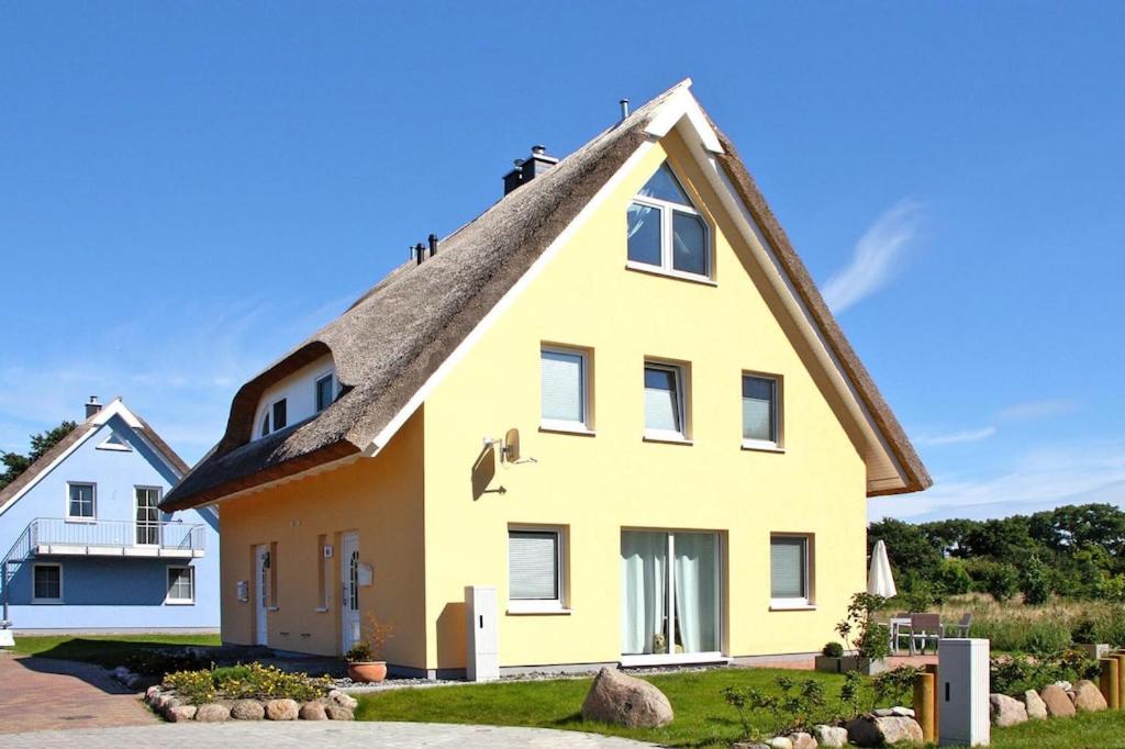 维埃雷格Doppelhaushälfte Westwind im Hafendorf Vieregge的黄色的茅草屋顶度假屋