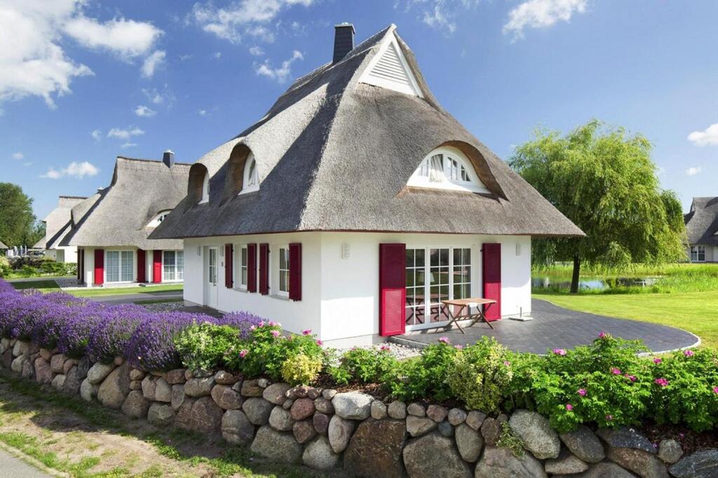 富伦多夫Holiday house, Fuhlendorf的小屋设有茅草屋顶和石墙