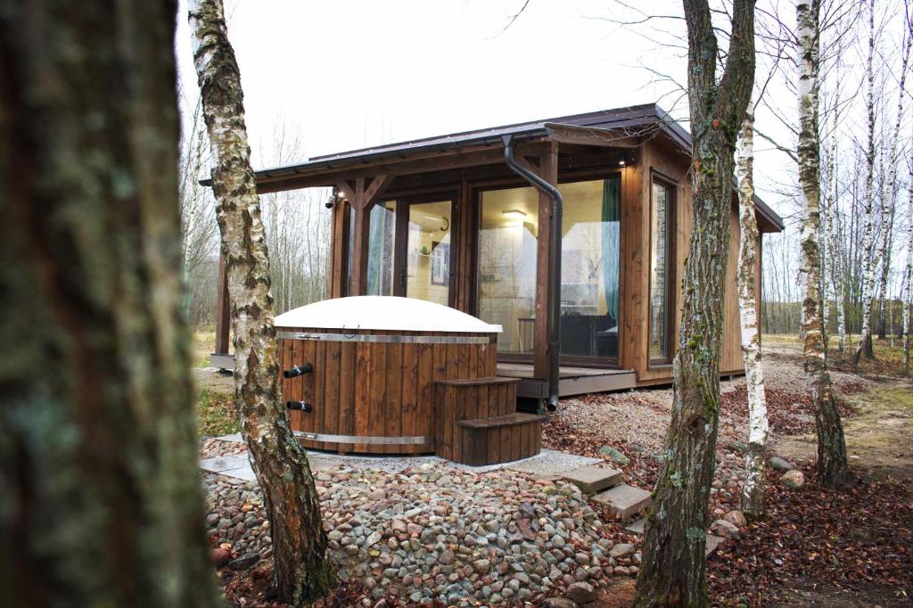 GražuliaiRiešutynė的木头小屋,设有热水浴池