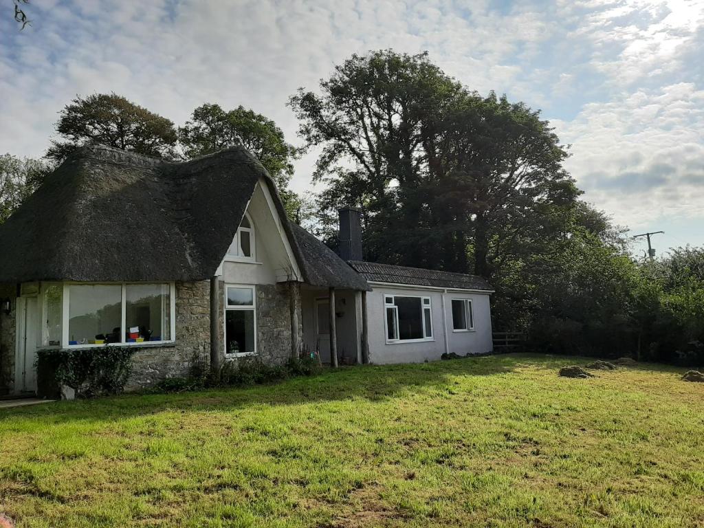 普里茅斯Quintessential, secluded South Devon cottage的庭院中一座带茅草屋顶的老房子