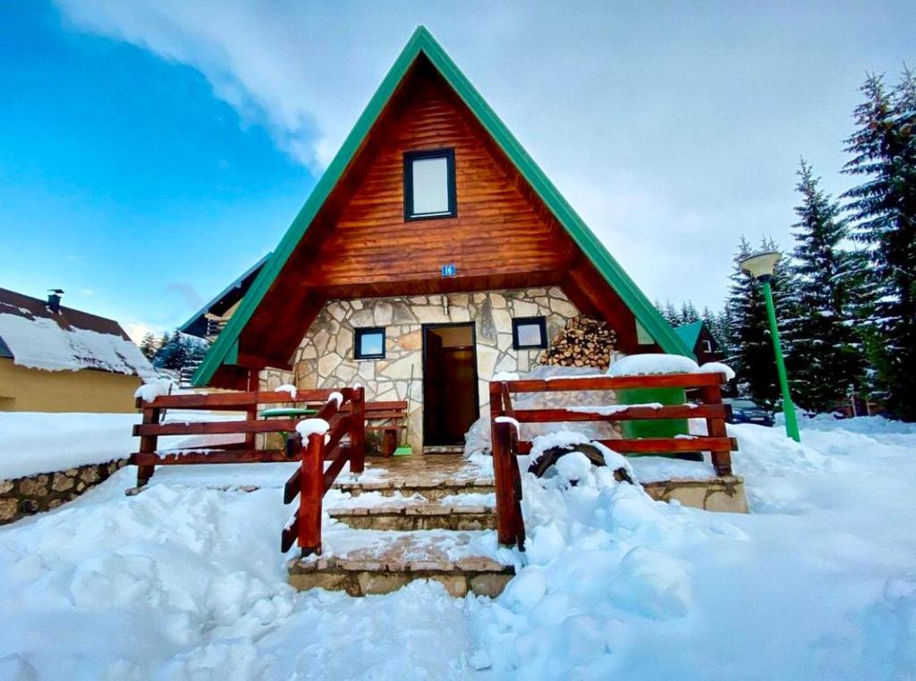 扎布利亚克Holiday Home Vojinovic的雪中带绿色屋顶的房子