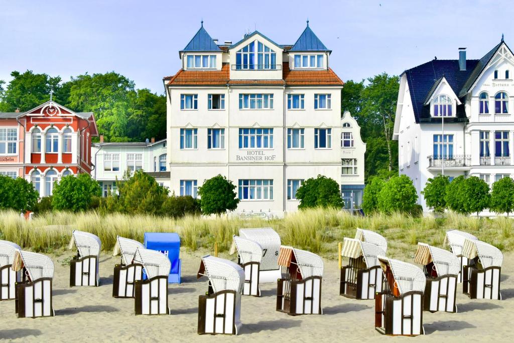 赛巴特班森班希诺霍夫沙滩酒店的坐在建筑物前沙子上的一组椅子