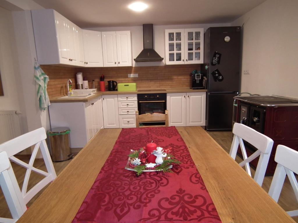 HerálecChalupa Agáta的厨房里设有一张桌子,上面有红色地毯