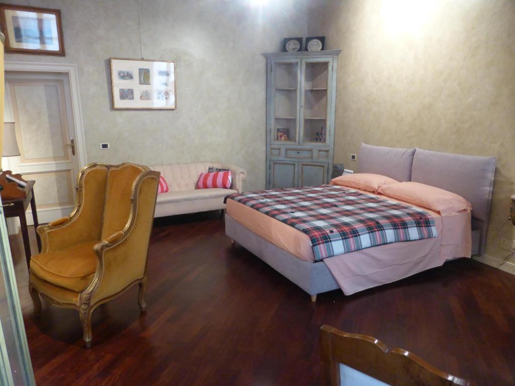 布雷西亚Galleria d'Arte - Foresteria的一间卧室配有一张床和一把椅子