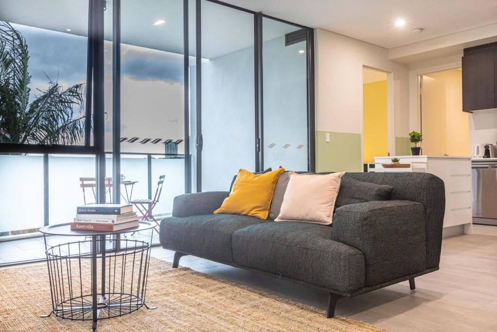 悉尼KULA Parramatta的客厅配有沙发和桌子