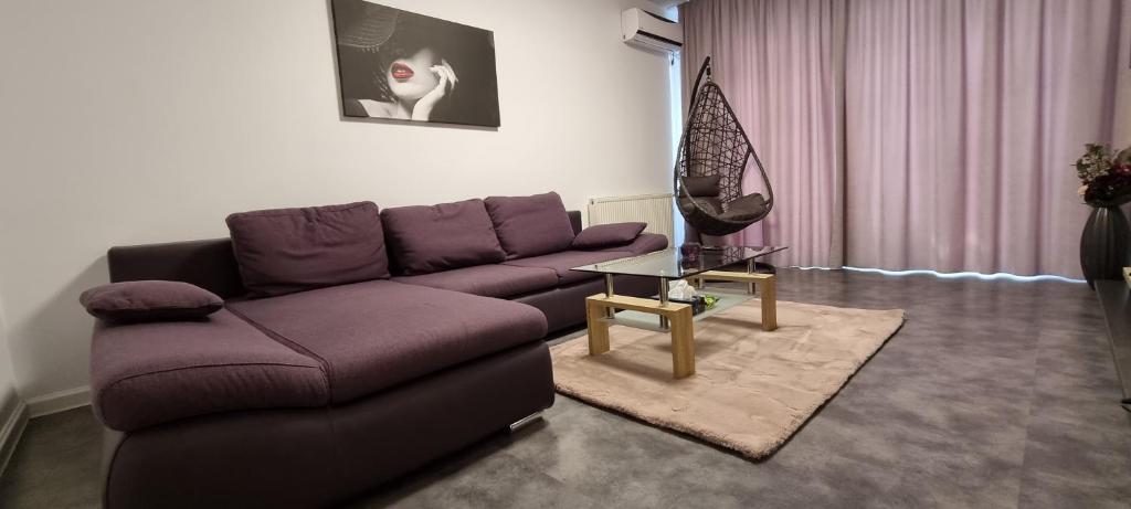 北马马亚-讷沃达里Andrew Beach Apartment的客厅配有紫色沙发和桌子
