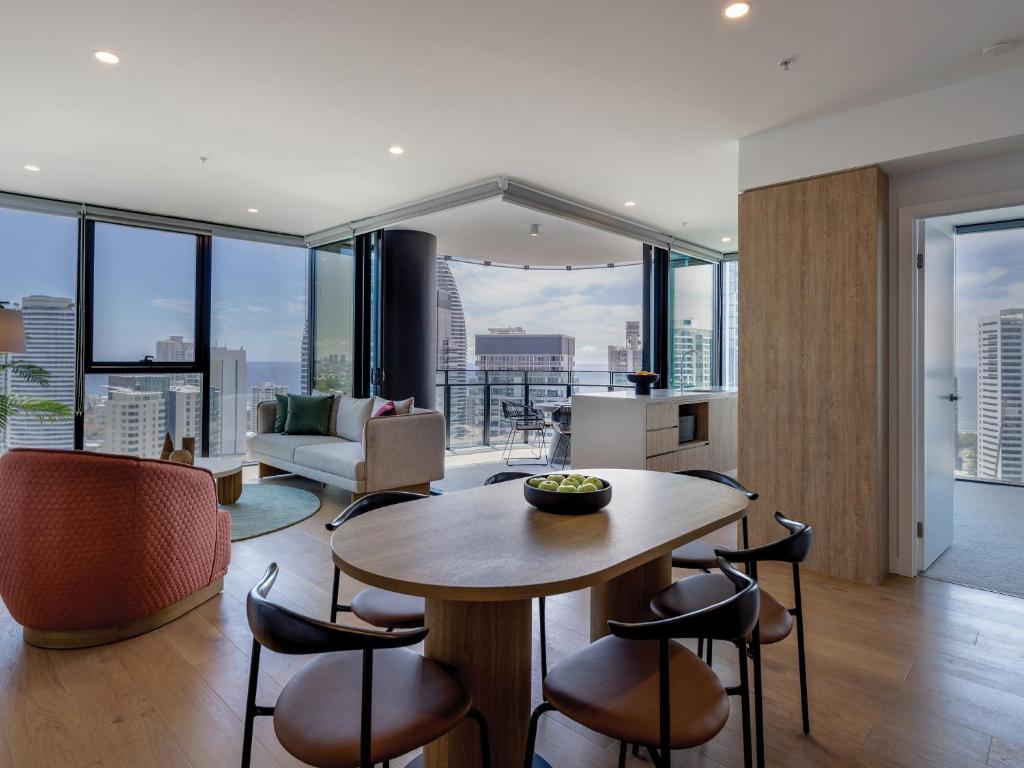 黄金海岸The Star Residences - Gold Coast的厨房以及带桌椅的起居室。
