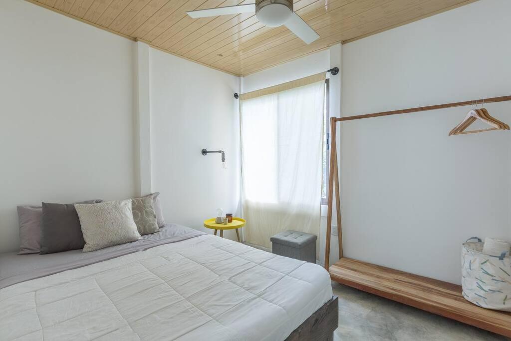 圣塔特蕾莎海滩Ambar House的一间卧室设有一张床和一个大窗户