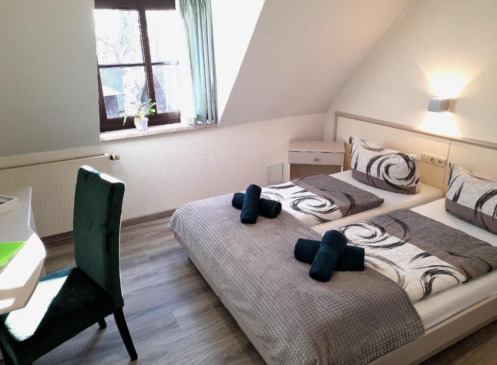 科特布斯Hotel Zum Postkutscher的一间卧室配有两张床、一张桌子和一张桌子