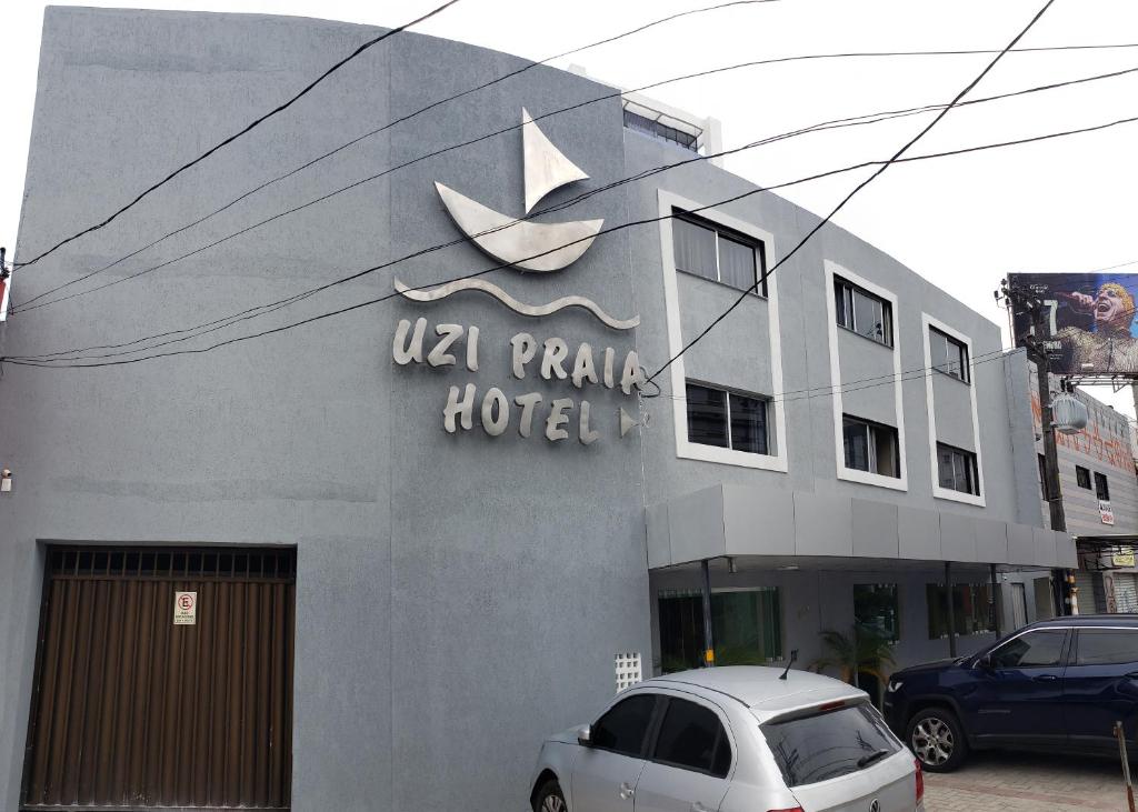 累西腓Hotel Uzi Praia的停在酒店前的白色汽车