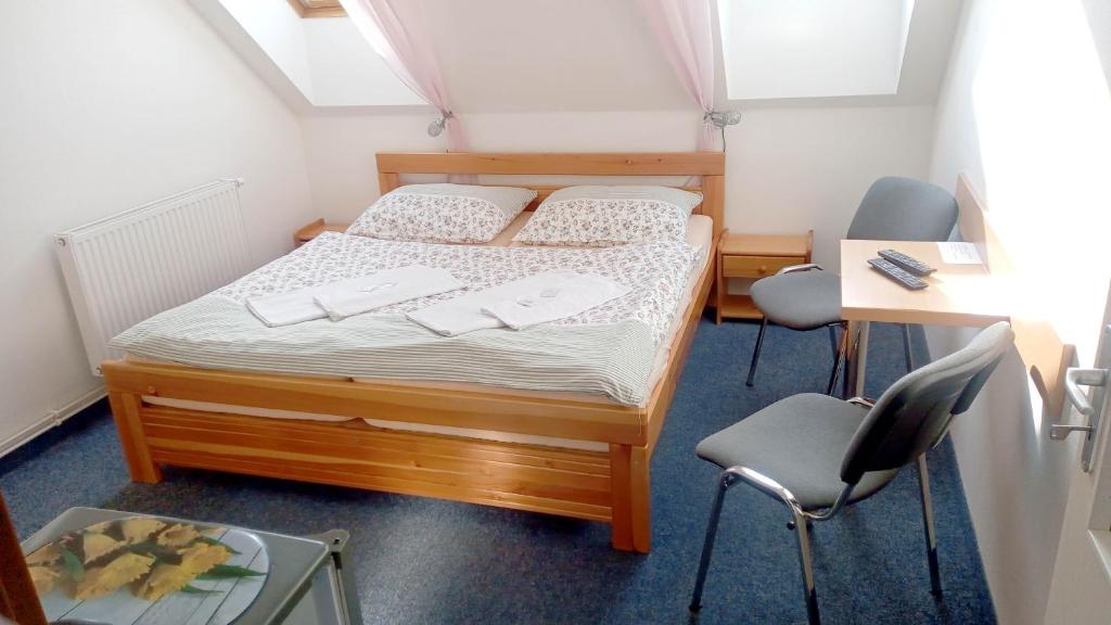 伏尔塔瓦河畔利普诺普利斯塔夫酒店的一间小卧室,配有一张床和两把椅子