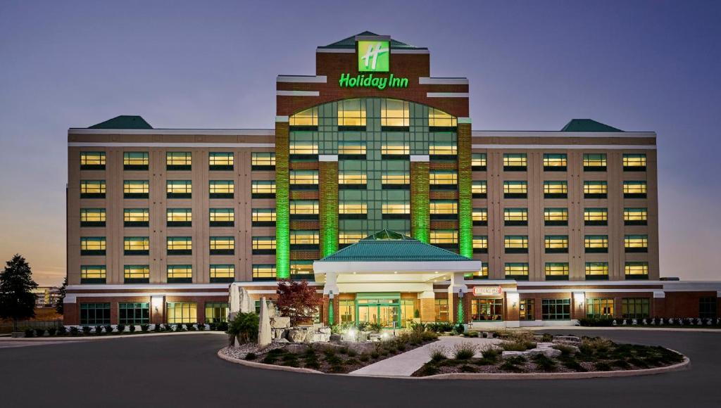 奥克维尔Holiday Inn & Suites Oakville at Bronte, an IHG Hotel的一座酒店大楼,上面有一个钟