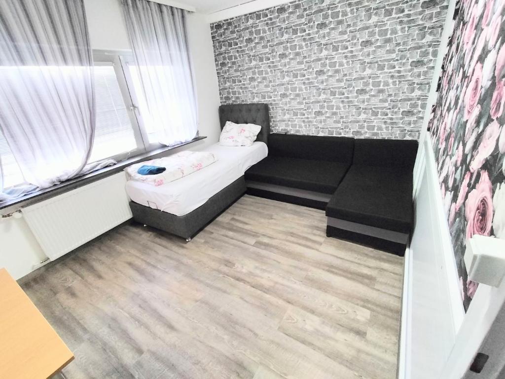 吕塞尔斯海姆FMI 44Accommodation的小房间配有沙发和砖墙
