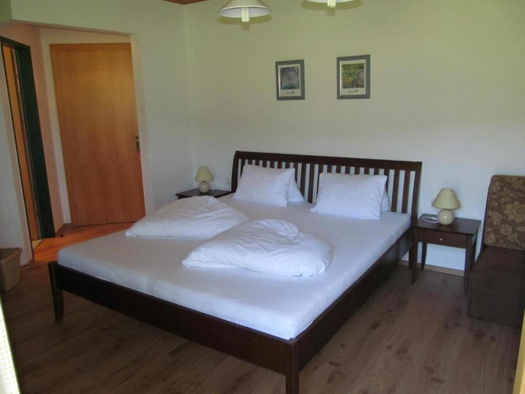 HöggenRoom in Apartment - Ferienhaus Kahr Appartment Rosbrand的一间卧室配有带白色床单和枕头的床。