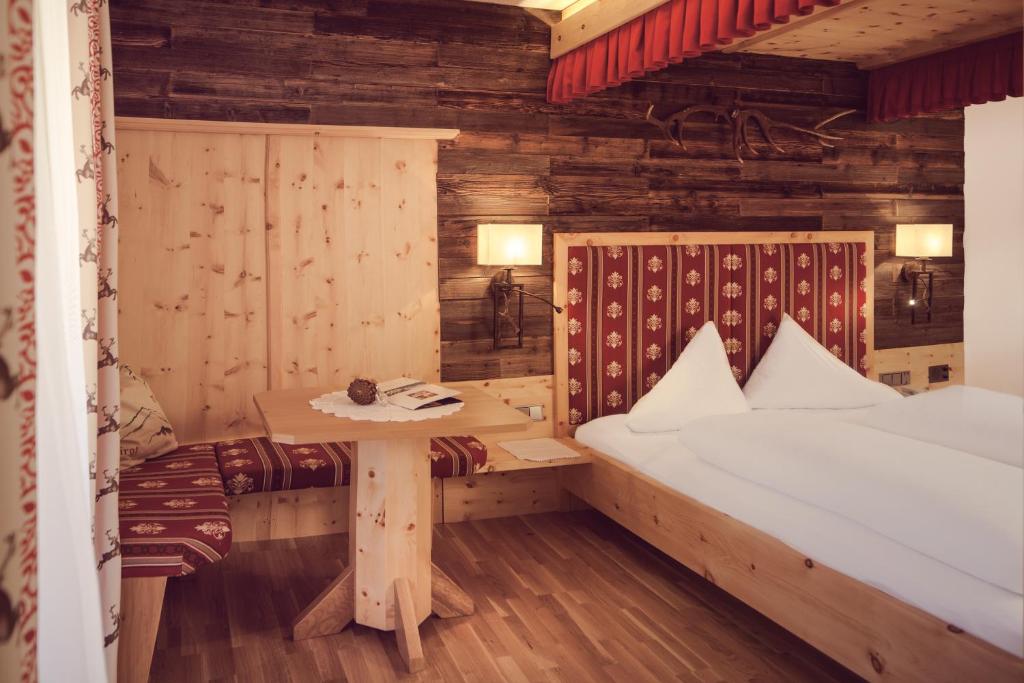 米德尔斯Hotel Alpenstolz的一间设有床铺和桌子的房间