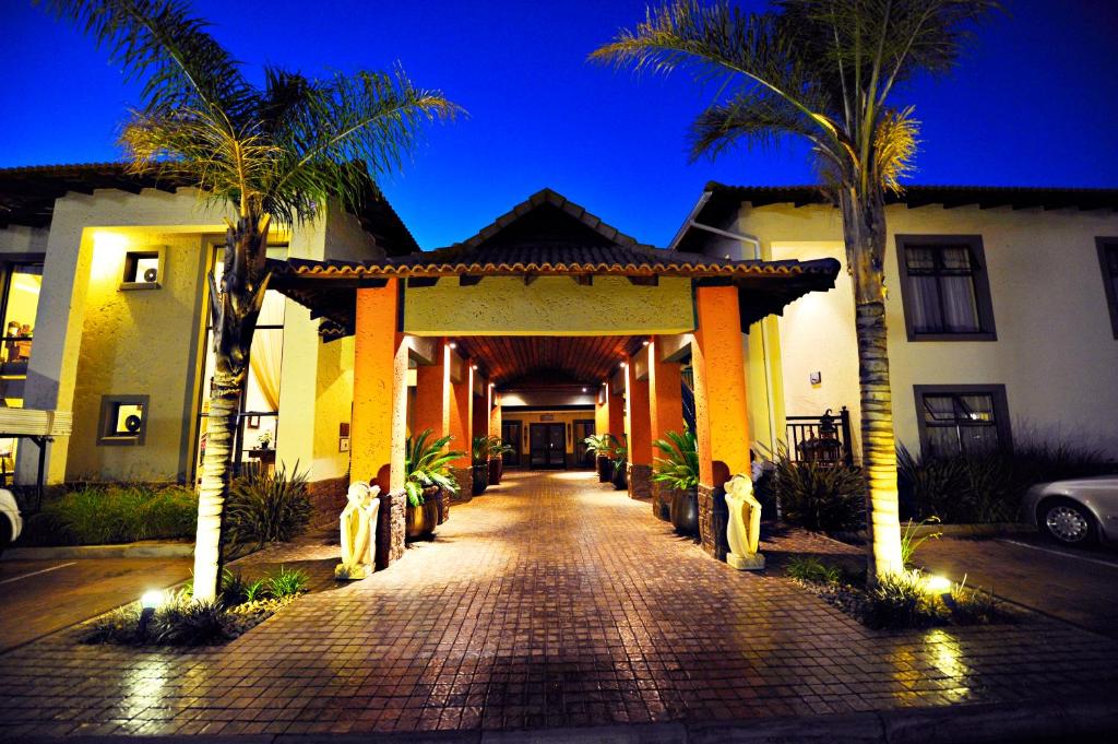 布隆方丹Villa Bali Luxury Guesthouse的走廊通往棕榈树屋