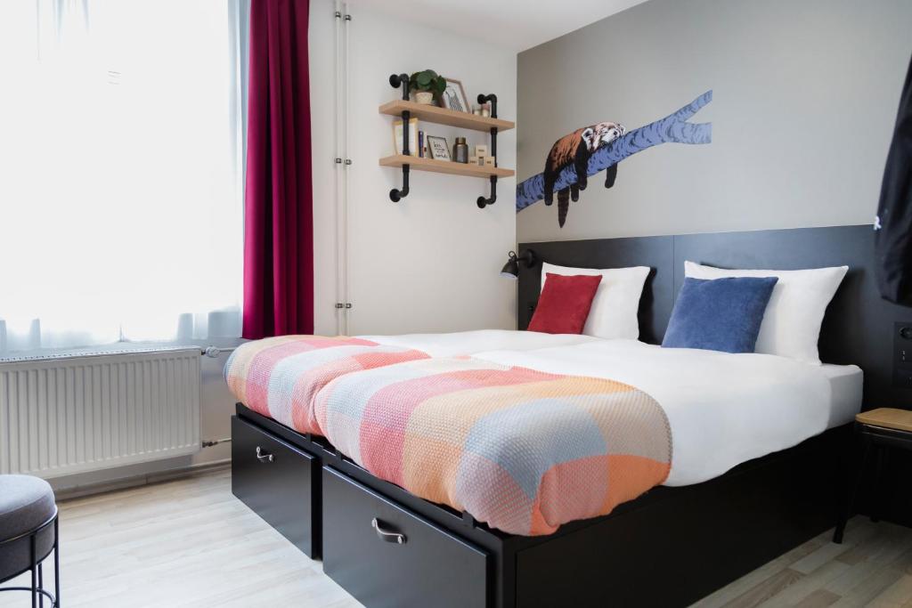 汉堡汉堡创造者旅舍的一间卧室配有一张大床,提供色彩缤纷的毯子和枕头