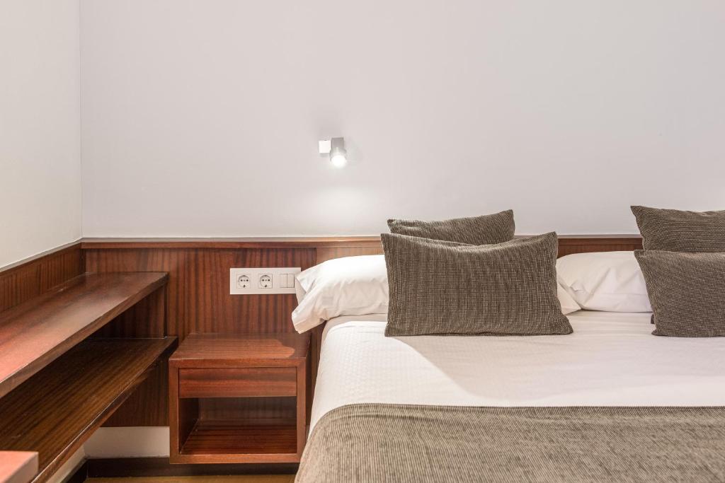 菲格拉斯Hotel Emporda的一间卧室设有两张床和木墙