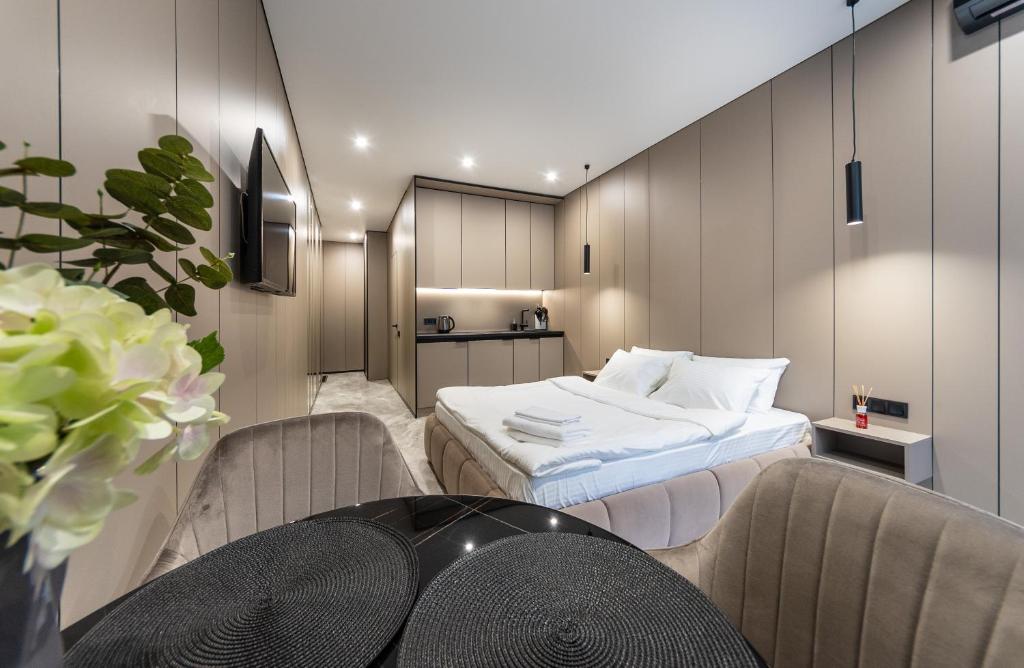 基辅Апартаменти-студіо "Premium Lux Apartments French Quarter 2" з гідромасажною ванною чи з душем的卧室配有一张床和一张桌子及椅子