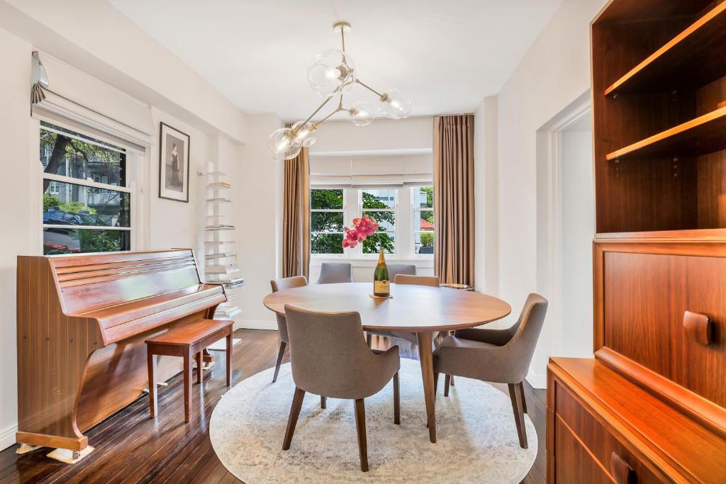 悉尼Premium Double Bay 3 bedroom apartment的一间带桌子和钢琴的用餐室