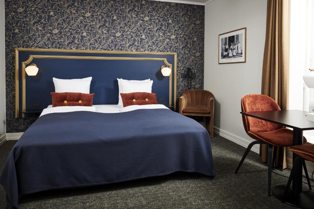 米泽尔法特斯咯塔海恩兹联盟酒店的酒店客房带蓝色的床和椅子
