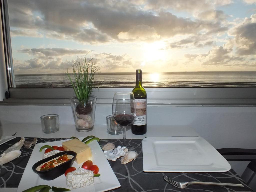 库克斯港Watten-Blick 2的一张桌子,上面放着一瓶葡萄酒和一盘食物
