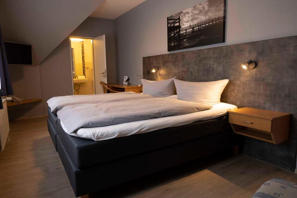 伦茨堡伦茨堡酒店的一间卧室配有一张带白色床单的大床
