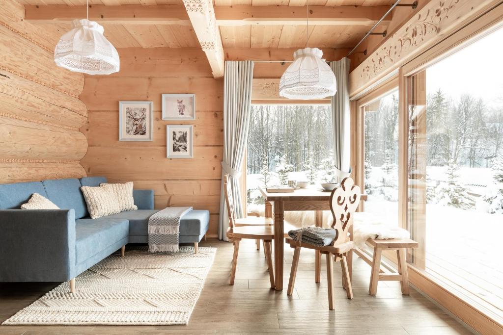 考斯赛力克Śnieżna Dolina - Sobiczkowa Bór Luxury Chalets的客厅配有蓝色的沙发和桌子