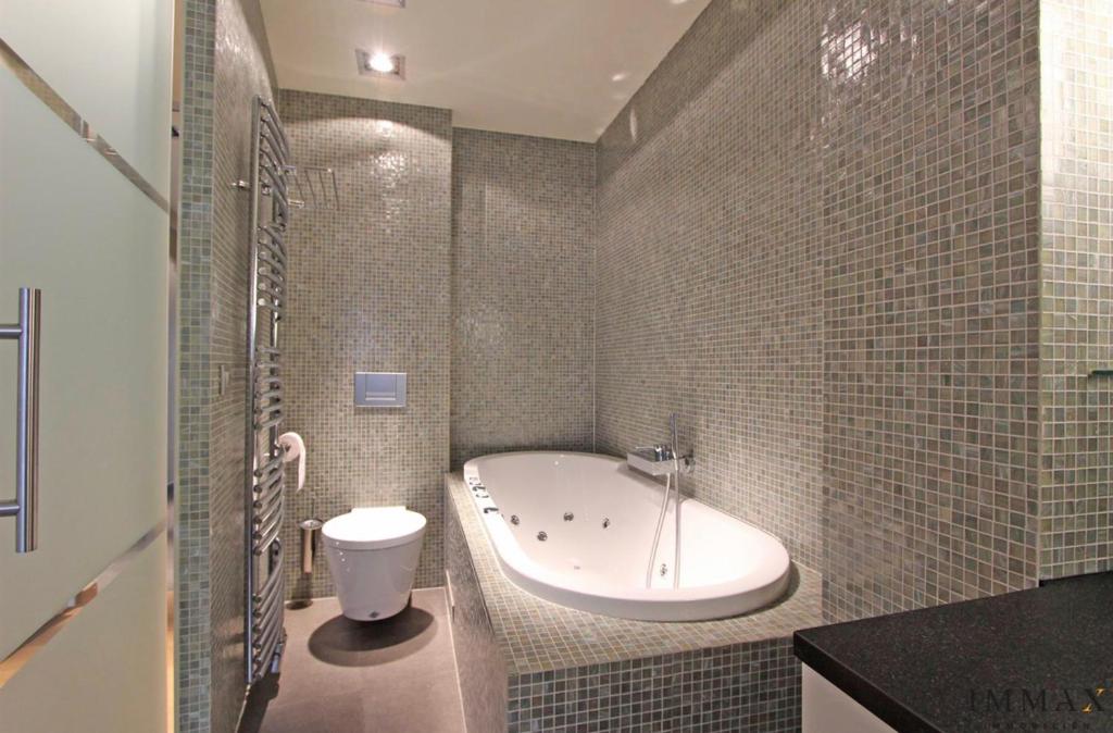 克诺克－海斯特Appartement Sunny home Deluxe的带浴缸、卫生间和盥洗盆的浴室