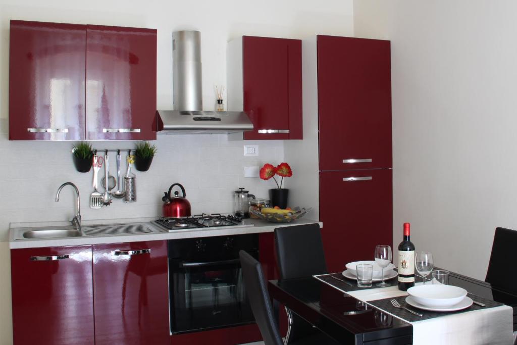 佛罗伦萨圣安特尼诺公寓的厨房配有红色橱柜和带水槽的桌子